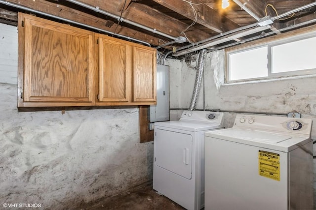 clothes washing area with cabinets, washer and dryer, and electric panel