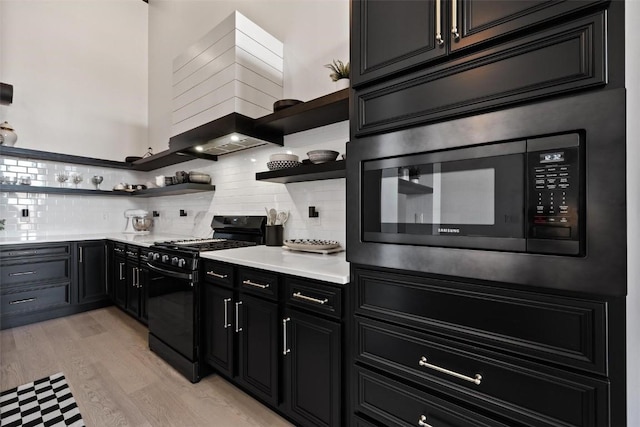 kitchen with gas stove, light hardwood / wood-style flooring, and tasteful backsplash