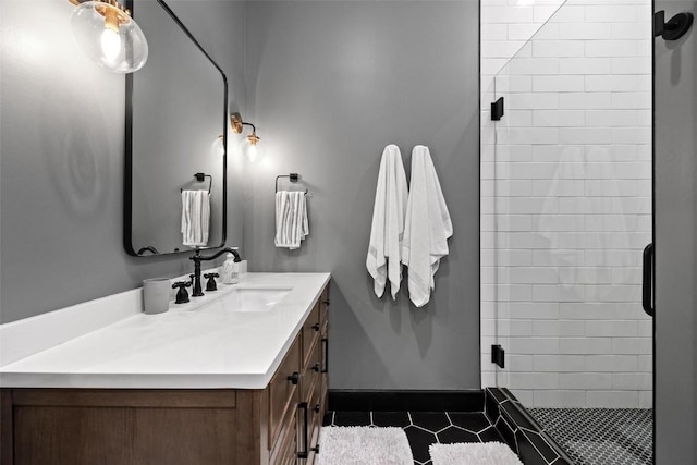 bathroom with a shower with door, vanity, and tile patterned flooring