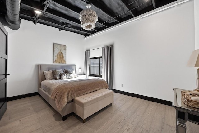 bedroom with baseboards and light wood finished floors