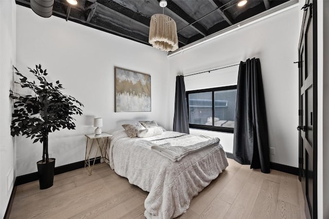 bedroom with light wood-style flooring and baseboards