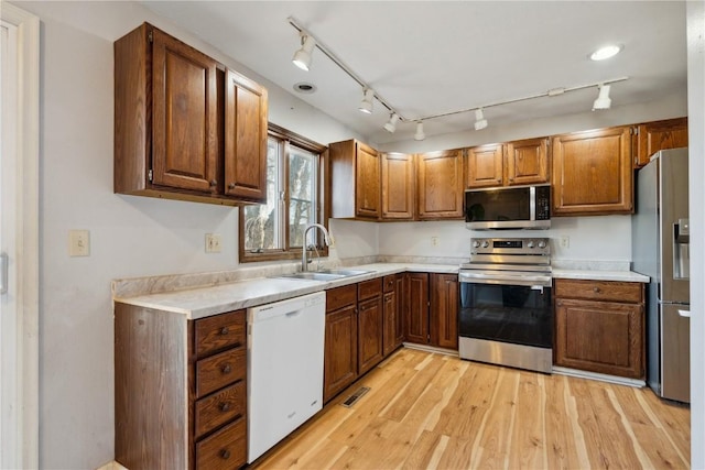 kitchen featuring sink, stainless steel appliances, and light hardwood / wood-style floors