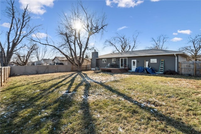 back of property featuring a wooden deck and a yard