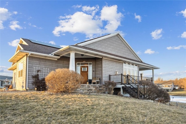 view of front of house with a front yard and solar panels