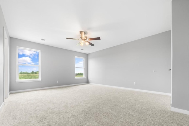 empty room featuring ceiling fan and light carpet