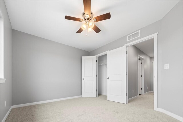 unfurnished bedroom featuring light carpet, ceiling fan, and a closet