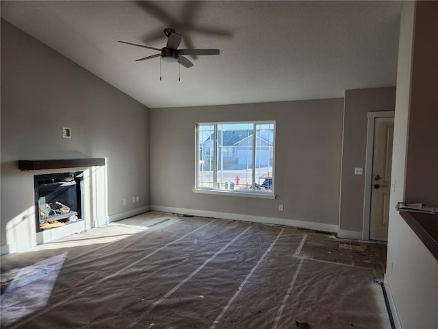 unfurnished living room featuring vaulted ceiling and ceiling fan