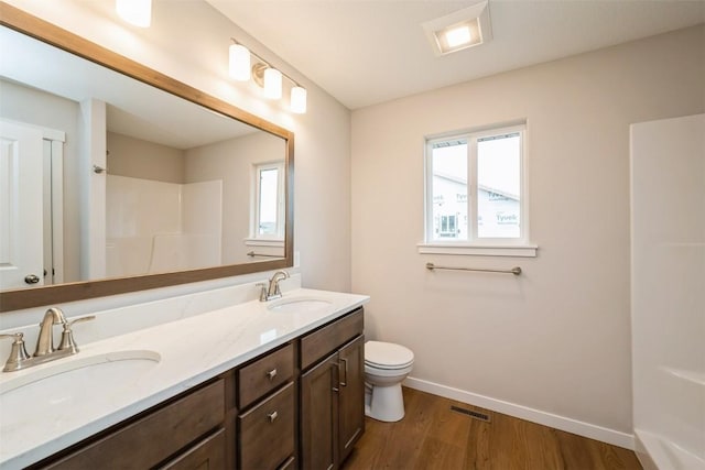 6188 Cope Dr, Marion, IA 52302 - bathroom with double vanity, plenty of natural light, wood finished floors, and toilet