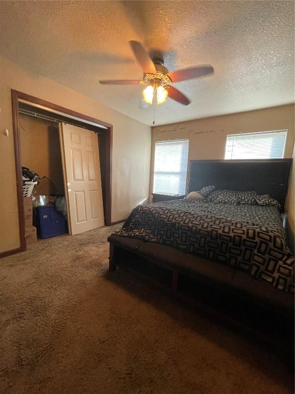 bedroom with a textured ceiling, a closet, ceiling fan, and carpet