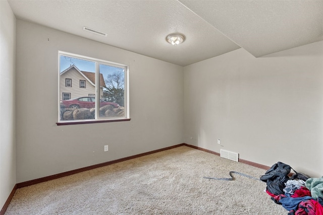 carpeted empty room with a textured ceiling