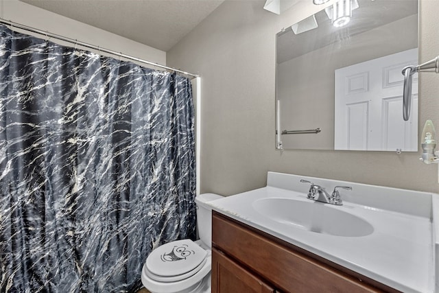 bathroom featuring vanity, a shower with curtain, toilet, and a textured ceiling