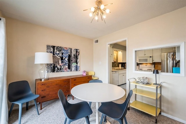 carpeted dining area featuring sink and a chandelier