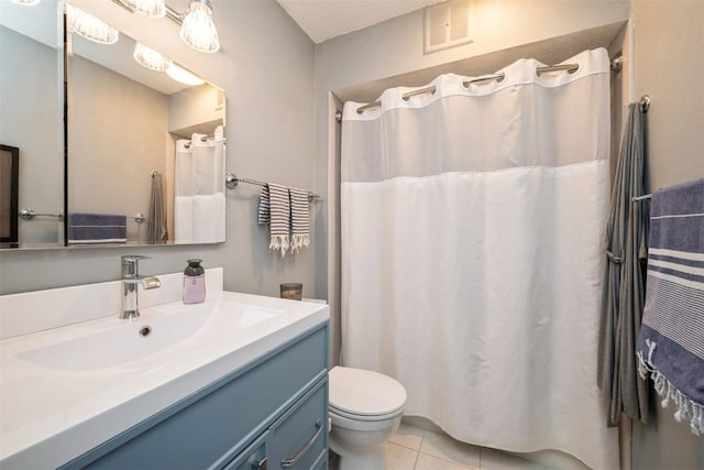 bathroom with toilet, vanity, tile patterned floors, and a textured ceiling