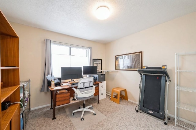 carpeted home office featuring a textured ceiling