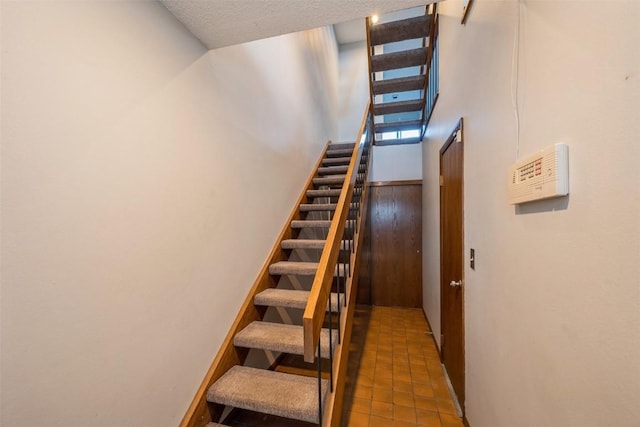 stairs featuring a textured ceiling and tile patterned floors