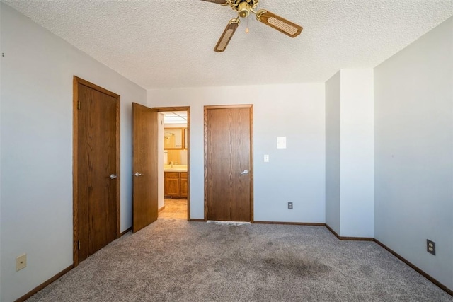 unfurnished bedroom with ceiling fan, light carpet, and a textured ceiling