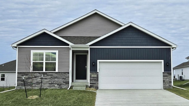 craftsman inspired home featuring a front lawn, a garage, and cooling unit