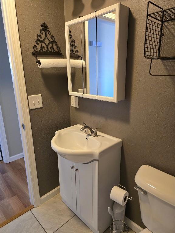 bathroom featuring tile patterned floors, toilet, and vanity