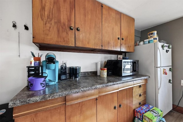 kitchen featuring wood-type flooring and white refrigerator