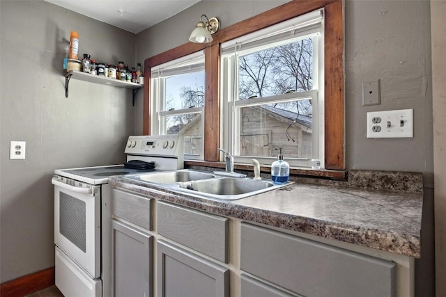 kitchen with a wealth of natural light, white range with electric cooktop, and sink