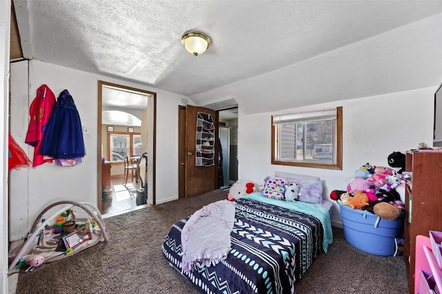 bedroom with carpet floors, vaulted ceiling, and a textured ceiling