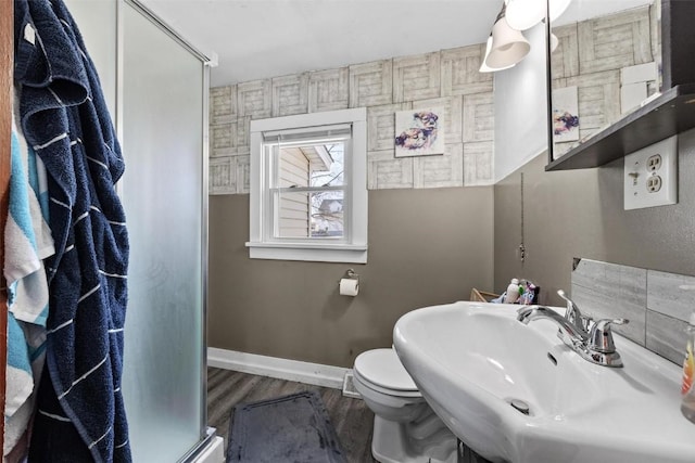 bathroom with toilet, a shower with shower door, hardwood / wood-style flooring, and sink