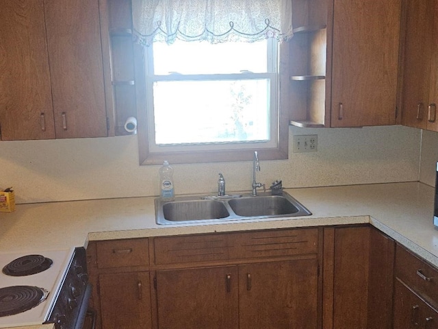 kitchen featuring electric range oven and sink