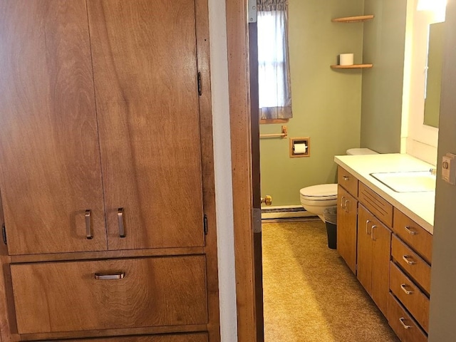 bathroom featuring baseboard heating, toilet, and vanity