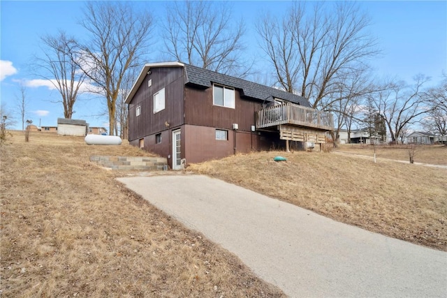 view of property exterior featuring a wooden deck and a lawn