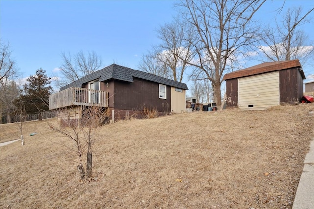 view of side of home with a deck, an outdoor structure, and a garage