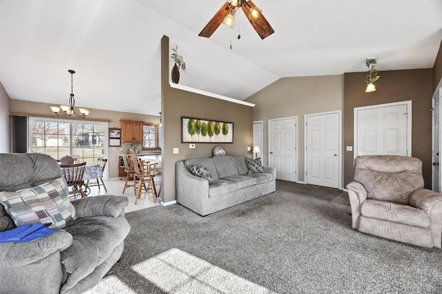 carpeted living room with ceiling fan with notable chandelier and vaulted ceiling