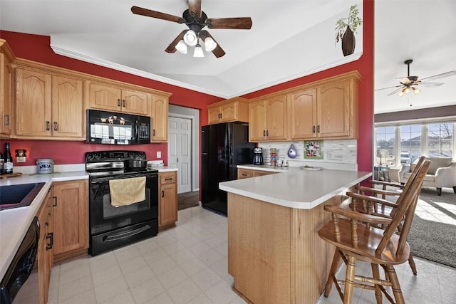 kitchen featuring black appliances, lofted ceiling, a kitchen bar, kitchen peninsula, and ceiling fan