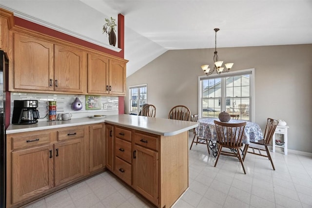 kitchen featuring decorative backsplash, hanging light fixtures, lofted ceiling, and kitchen peninsula