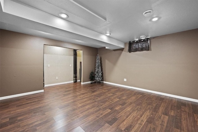 basement featuring a textured ceiling and dark hardwood / wood-style flooring