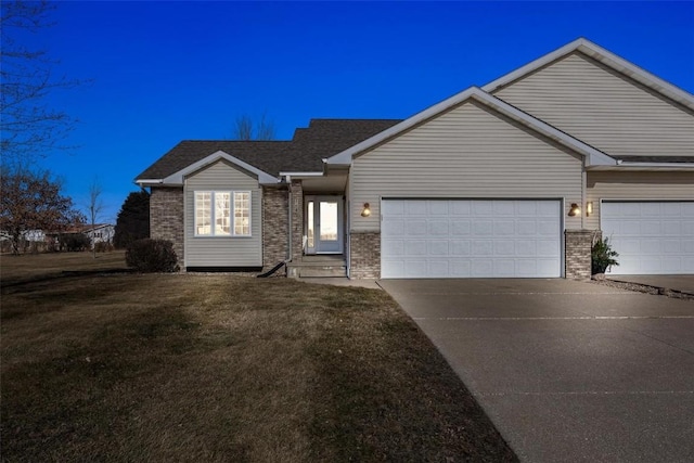 ranch-style house featuring a garage and a front lawn