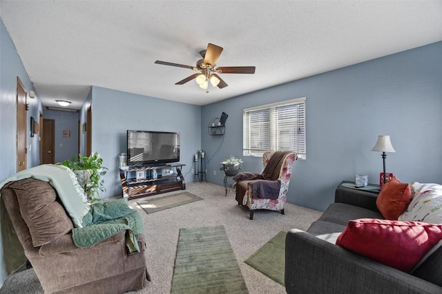 living room with light carpet, ceiling fan, and a textured ceiling