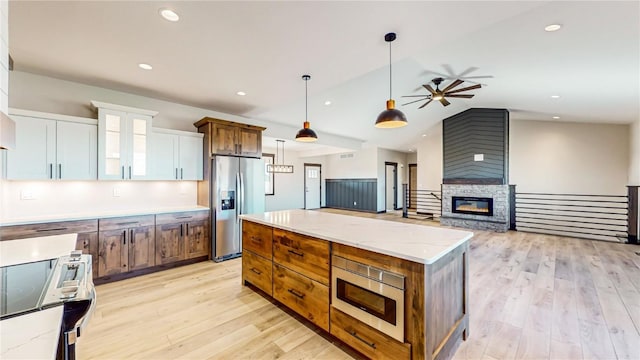 kitchen with a spacious island, lofted ceiling, white cabinetry, stainless steel appliances, and hanging light fixtures