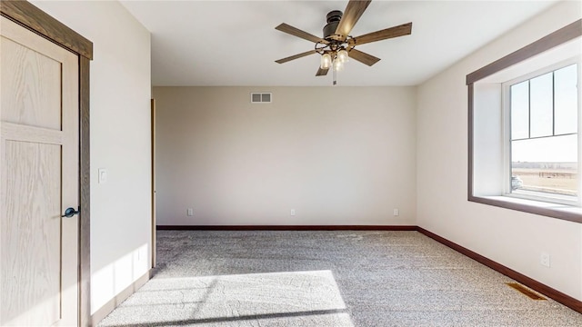 carpeted spare room featuring ceiling fan