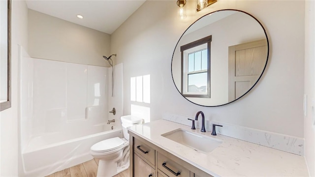 bathroom with bathing tub / shower combination, wood finished floors, toilet, and vanity