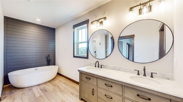 bathroom with a bath, hardwood / wood-style flooring, and vanity