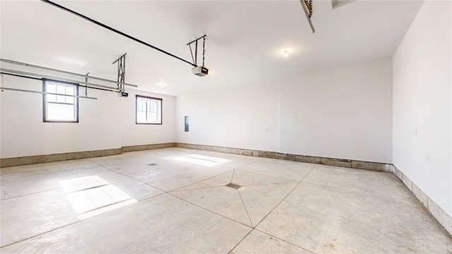 garage with baseboards and a garage door opener