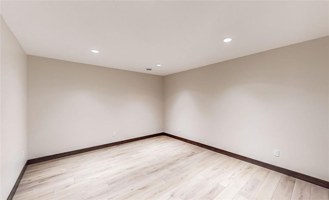spare room featuring baseboards, light wood-style flooring, and recessed lighting