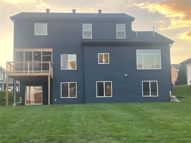 back house at dusk featuring a yard