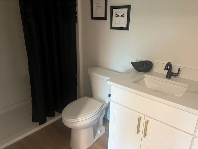 bathroom with toilet, a shower with shower curtain, wood-type flooring, and vanity