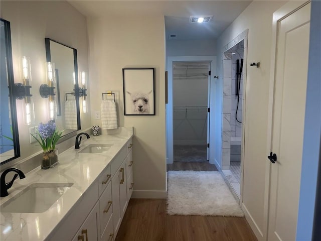 bathroom featuring hardwood / wood-style flooring, walk in shower, and vanity