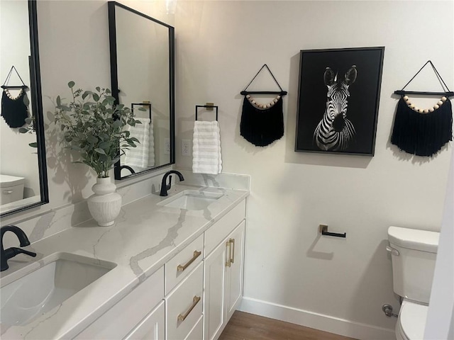 bathroom with hardwood / wood-style flooring, toilet, and vanity