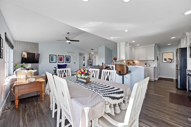 dining space featuring ceiling fan, dark hardwood / wood-style flooring, and vaulted ceiling