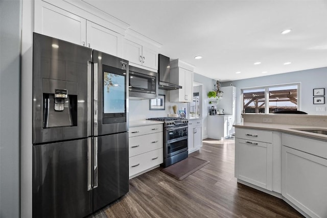 kitchen with black refrigerator with ice dispenser, built in microwave, white cabinetry, wall chimney range hood, and double oven range