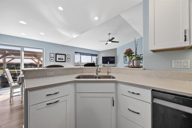 kitchen featuring ceiling fan, wood-type flooring, vaulted ceiling, white cabinets, and sink