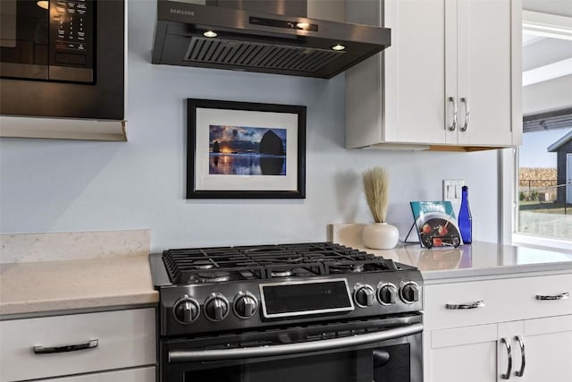 kitchen with light stone counters, white cabinets, stainless steel appliances, and extractor fan